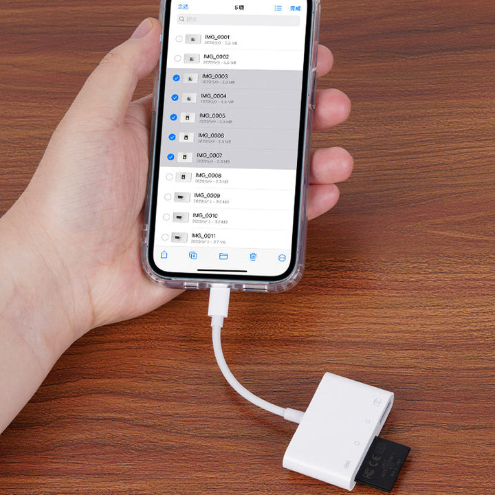 Universal mobile memory card reader next to a stack of digital photos, symbolizing easy photo transfer capabilities