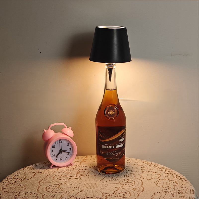 Modern cordless bottle lamp in use on a wooden table, showcasing its warm glow