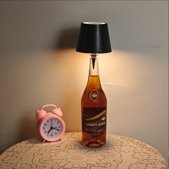 Modern cordless bottle lamp in use on a wooden table, showcasing its warm glow