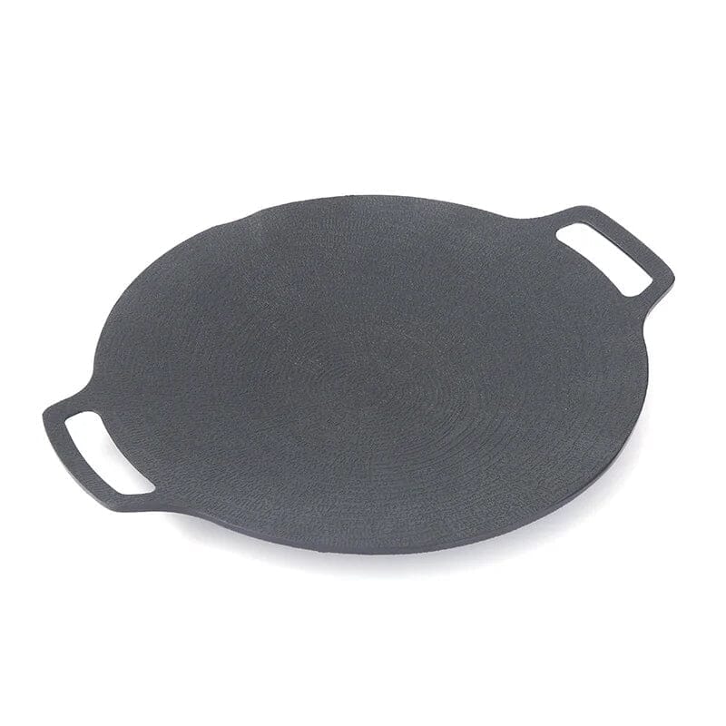 Non-stick round grill pan used over an open flame, demonstrating its outdoor cooking capability