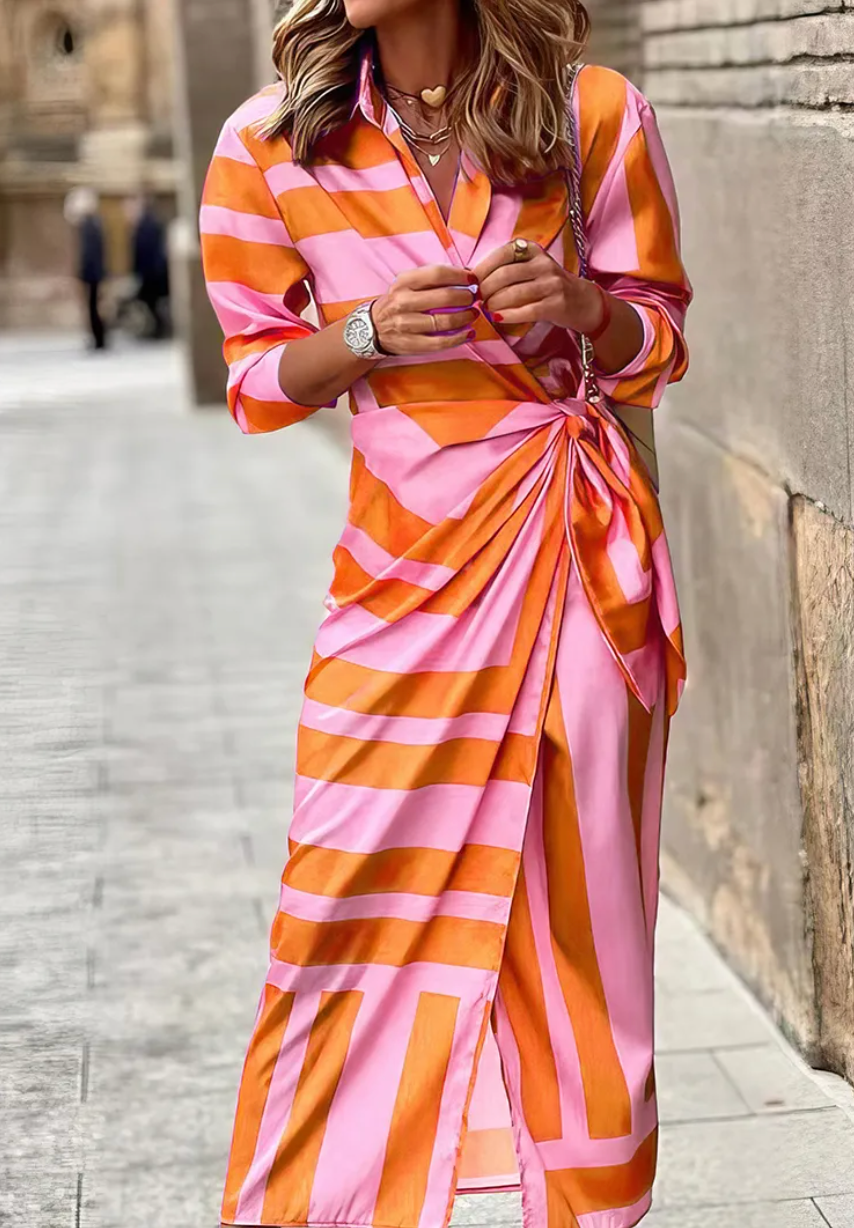 Chic women's printed wrap dress featuring a vibrant, colorful pattern. Ideal for summer casual or elegant wear.