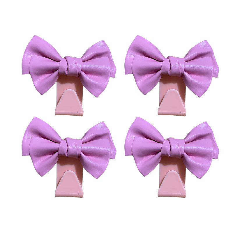 White bowknot car seat back hook from a side view, showing sturdy construction