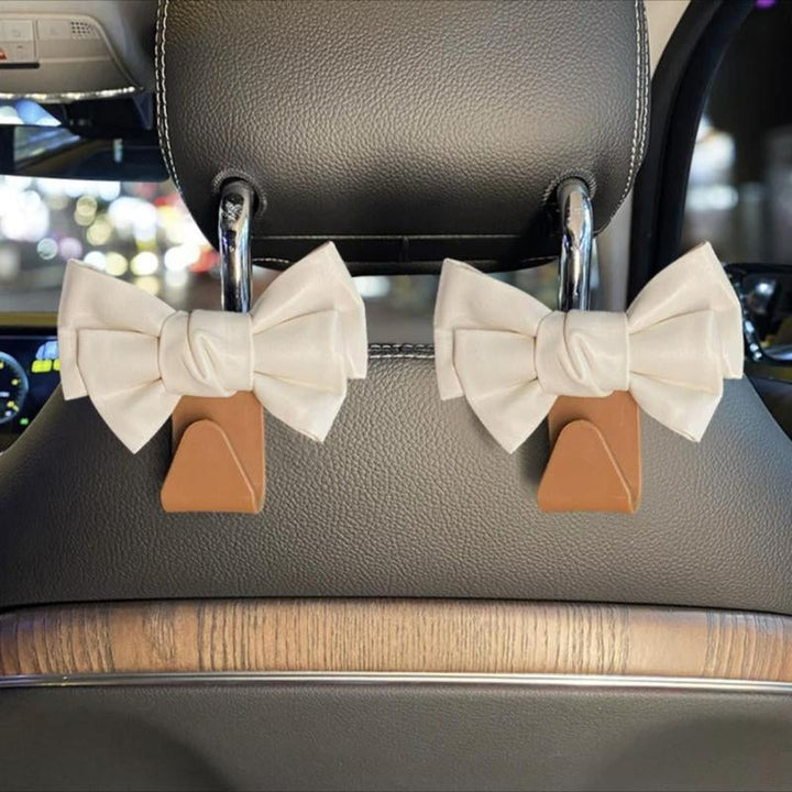 Stylish bowknot car seat hook holding a shopping bag, perfect for vehicle storage solution