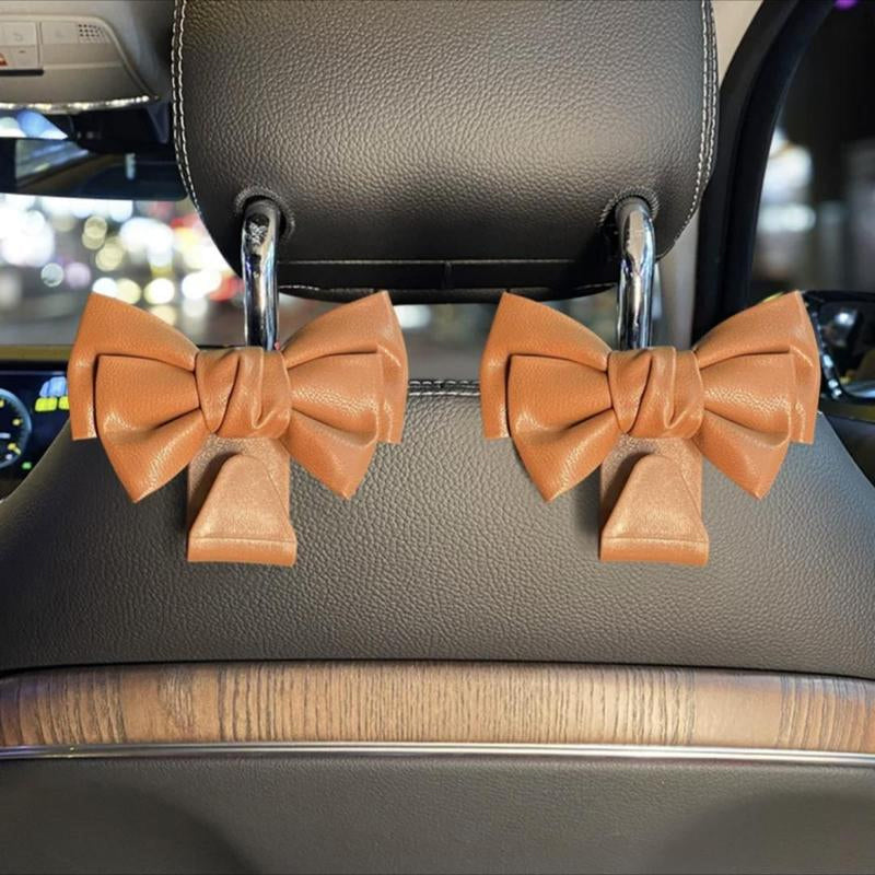 Car seat back hook with bowknot design, close-up showing texture and durable plastic