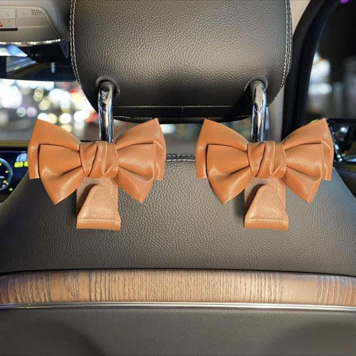 Car seat back hook with bowknot design, close-up showing texture and durable plastic