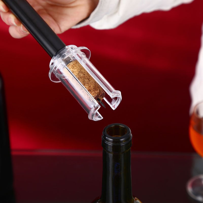 Wino On The Go wine opener set on a table next to a wine bottle and glasses, party ready