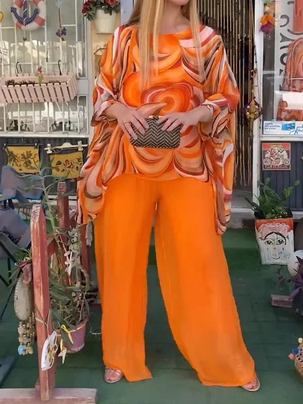 Vibrant abstract print women's set with a loose batwing top & flowy wide-leg pants. Perfect stylish resort wear.