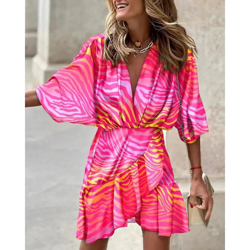 Women's abstract print mini dress with a chic V-neck, short sleeves, and playful ruffle hem. Perfect summer dress.