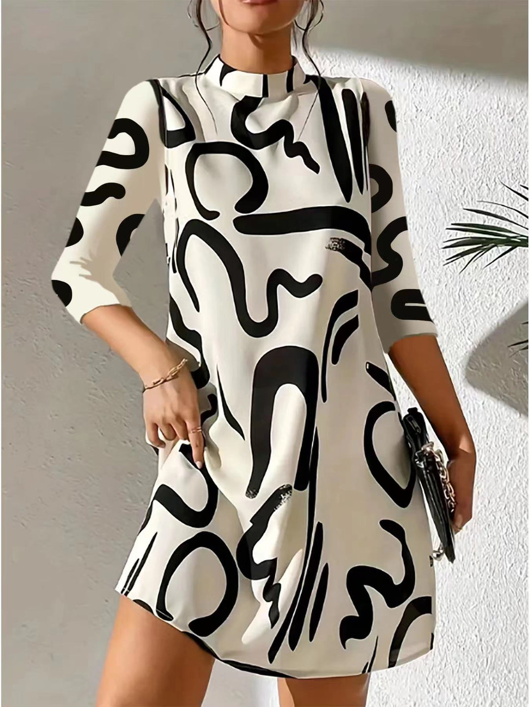 Stylish women's knee-length dress with a mock neck and unique abstract print. Three-quarter sleeves, modern casual look.