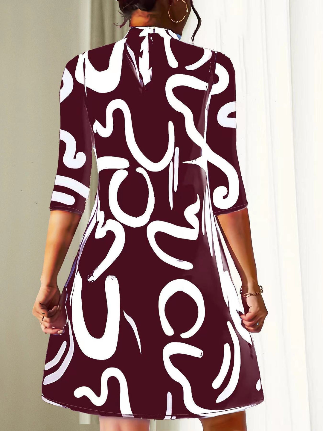 Modern women's abstract print mock neck dress. Loose-fit, three-quarter sleeve, knee-length for comfortable casual style.