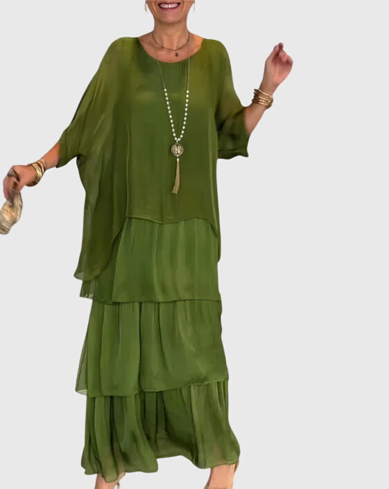 Women's flowy tiered maxi dress with a stylish abstract print, ideal for resort wear.