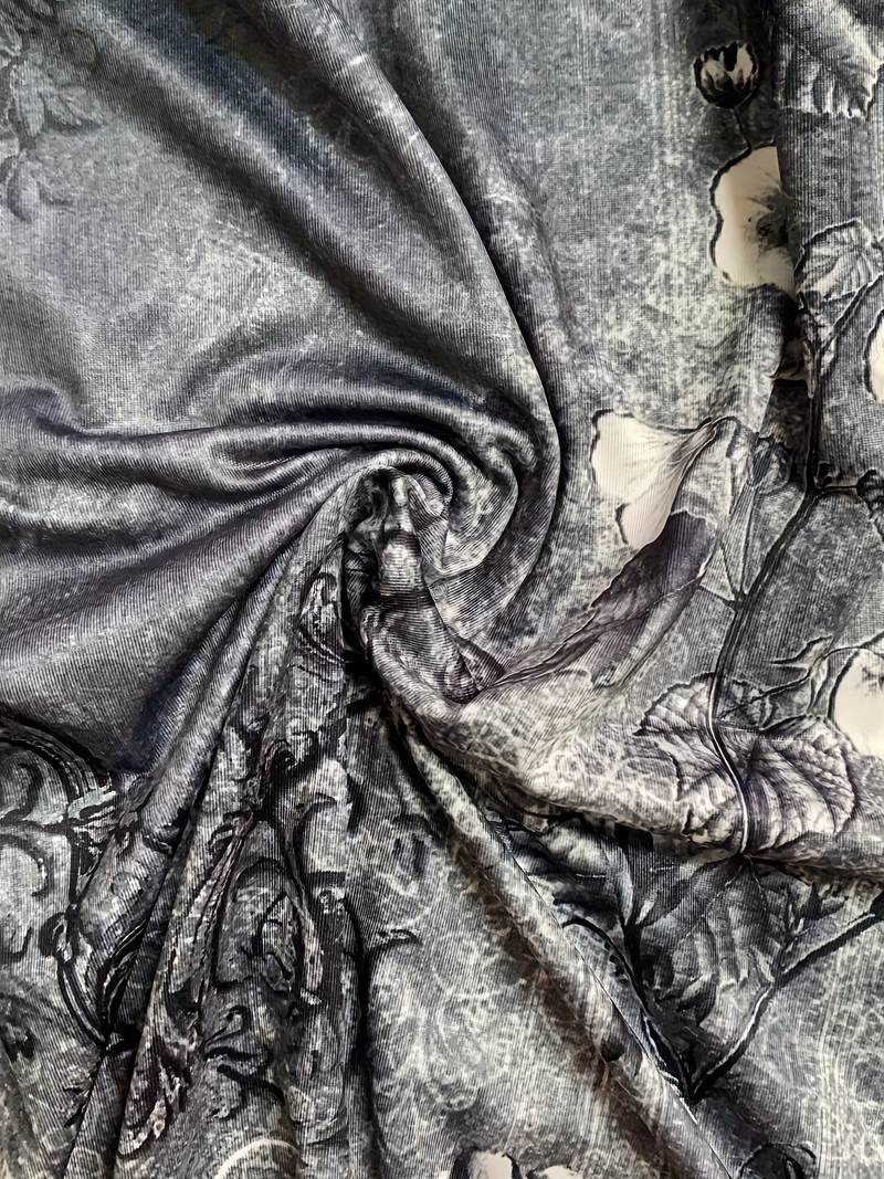 Close-up of the abstract print on a women's asymmetric midi dress, rich colors