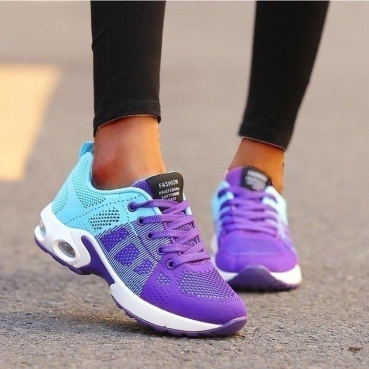 Close-up of a women's running shoe, showing breathable mesh upper and cushioned sole, white and black