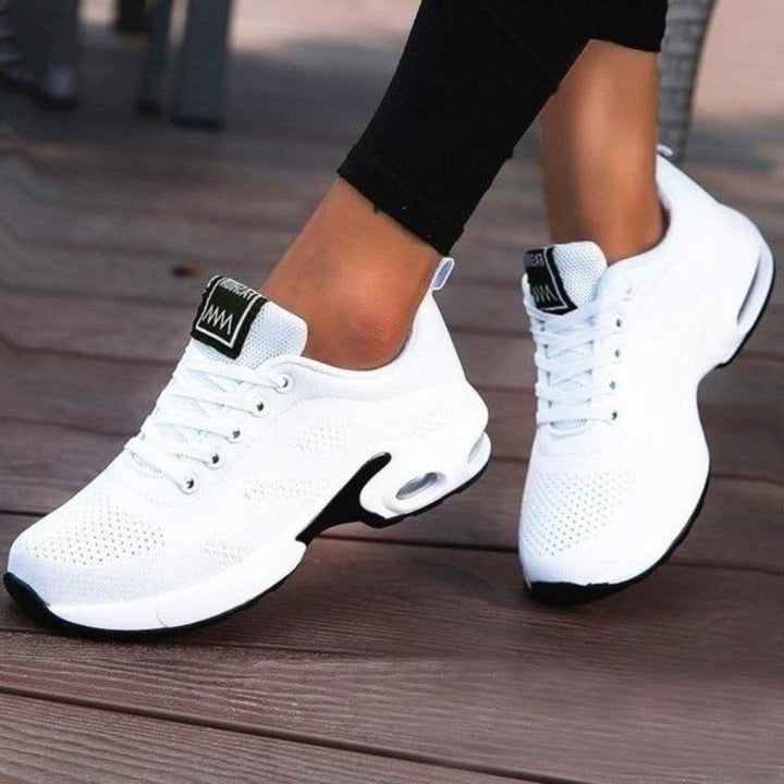 Pair of women's running shoes, black with neon green details, ideal for fitness and everyday wear