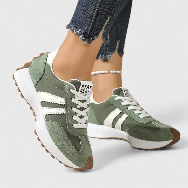 Stylish women's athletic trainers. Grey lace-up running shoes featuring a durable chunky sole for fitness.