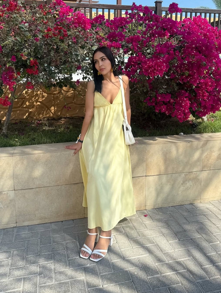 Elegant yellow women's backless maxi dress with spaghetti straps. Perfect for summer beach wear.