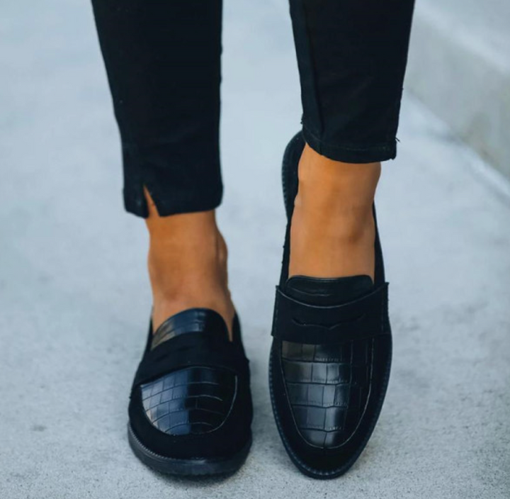 Close-up of women's slip-on loafers with detailed crocodile texture, perfect for professional style