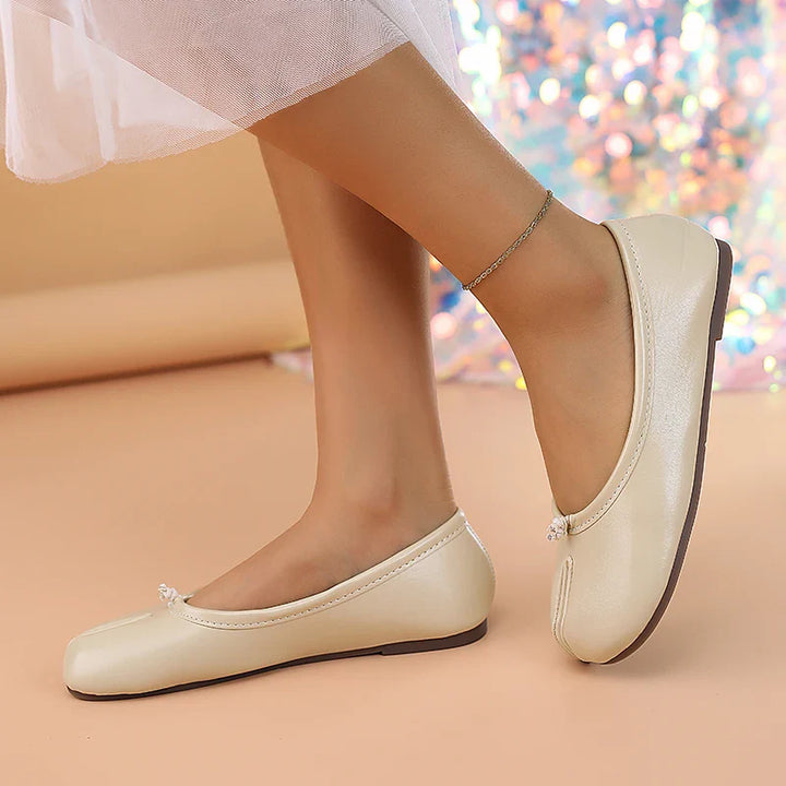 Modern women's flats in black, with a distinctive split toe and slip-on convenience.