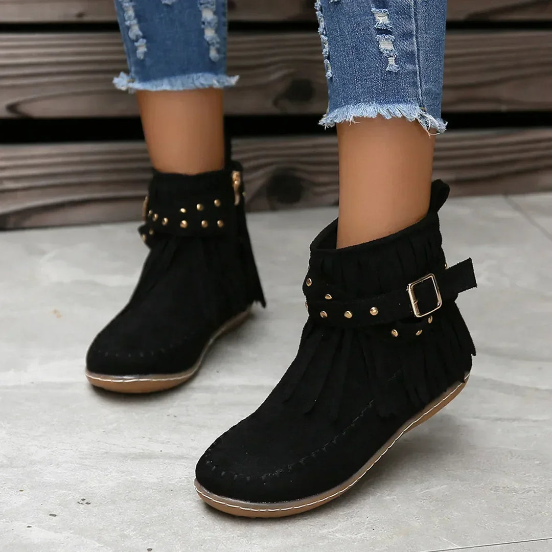 Close-up of warm-lined interior of women's black fringe ankle boots, cozy comfort
