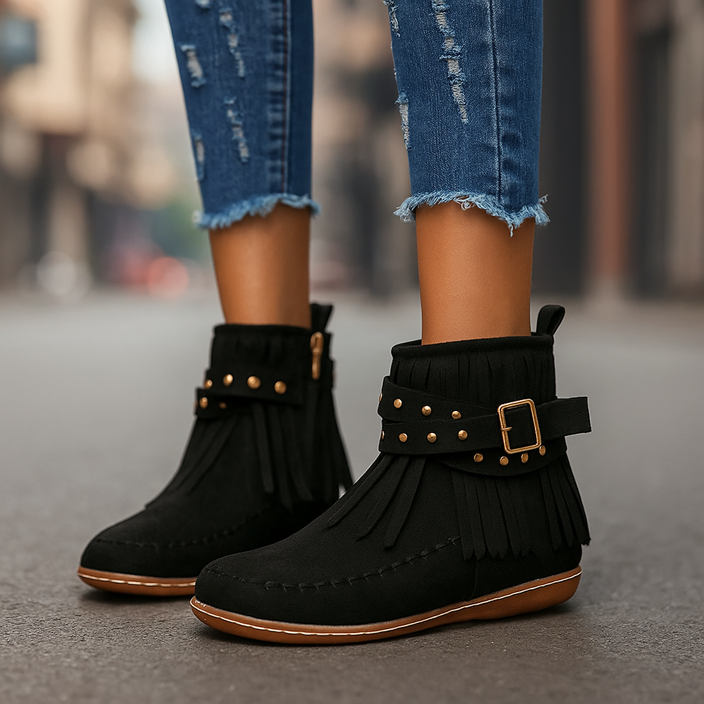 Close-up of studded buckle on women's black fringe ankle boots, warm-lined comfort