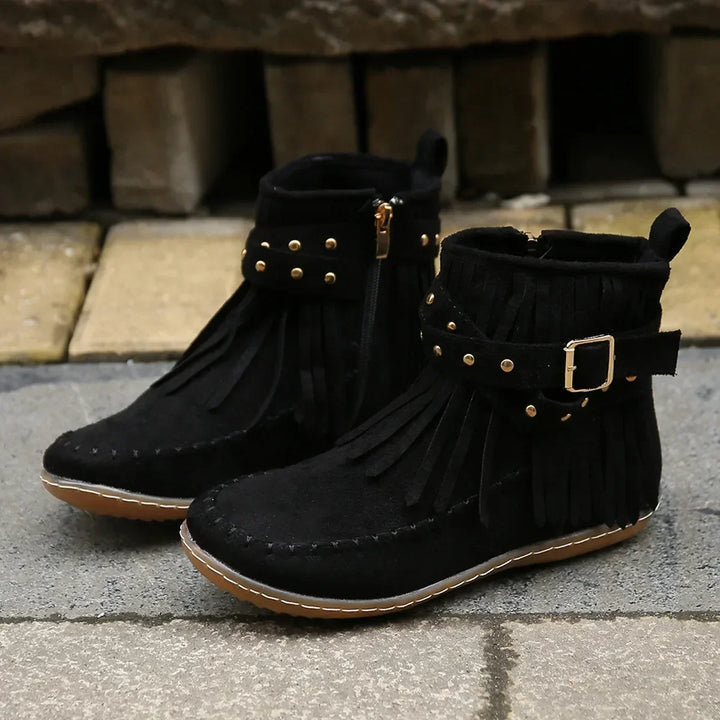 Detail of fringe on women's black ankle boots, suede-like material, studded buckle