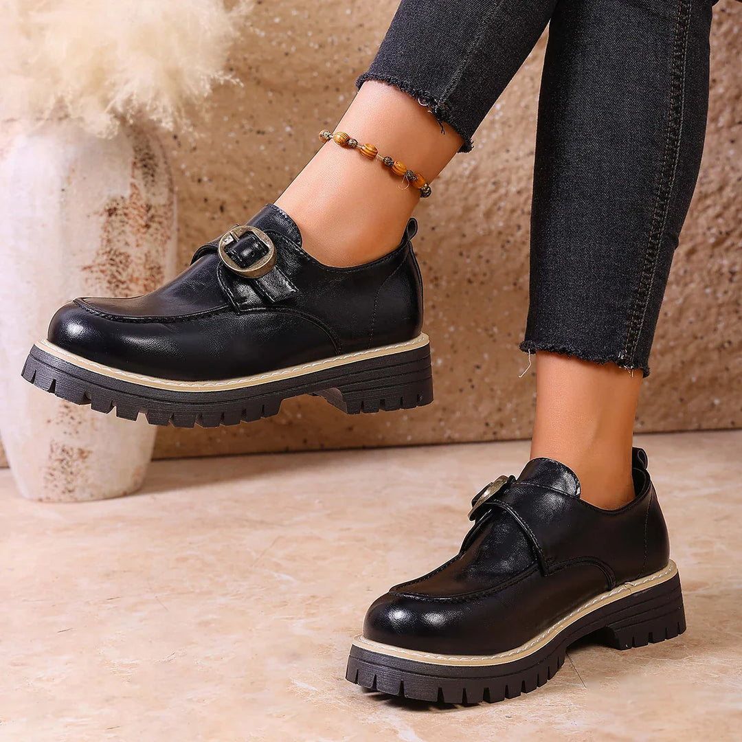 Winter-ready women's leather loafers featuring a sturdy buckle and flat sole.