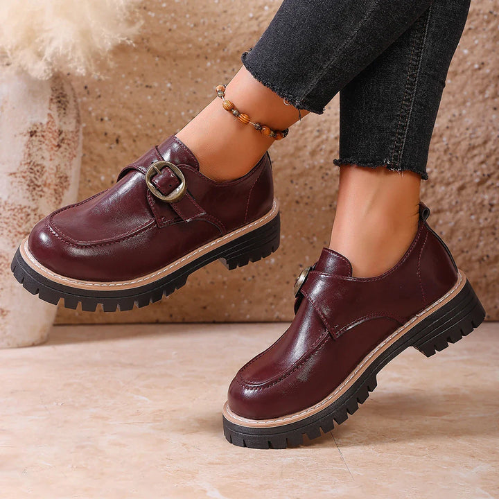 Close-up of a women's leather loafer showcasing the elegant buckle and stitching.