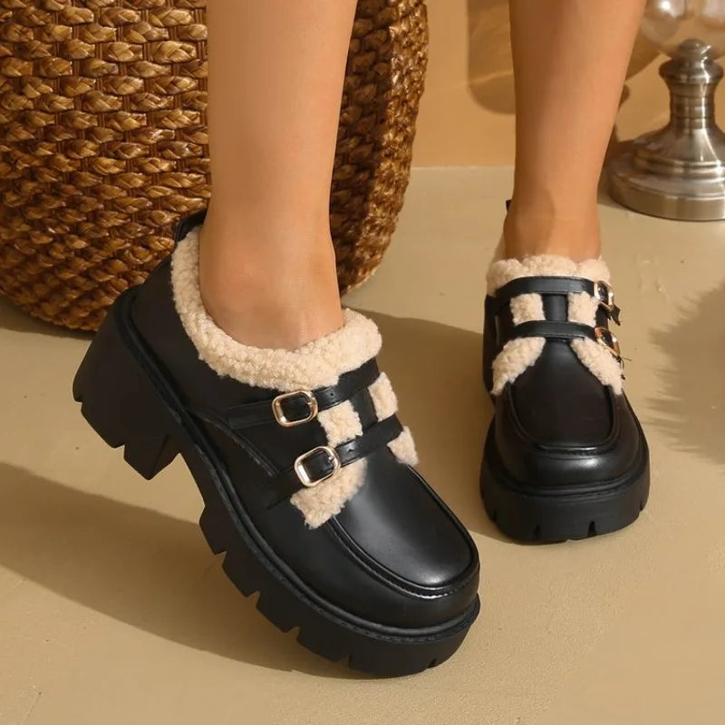 Pair of women's black leather platform shoes with prominent buckle, a trendy & warm winter option
