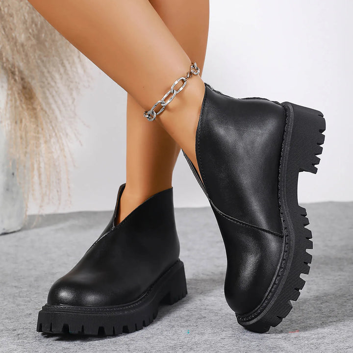 Side view of women's black leather platform slip-on shoes, versatile and trendy footwear.