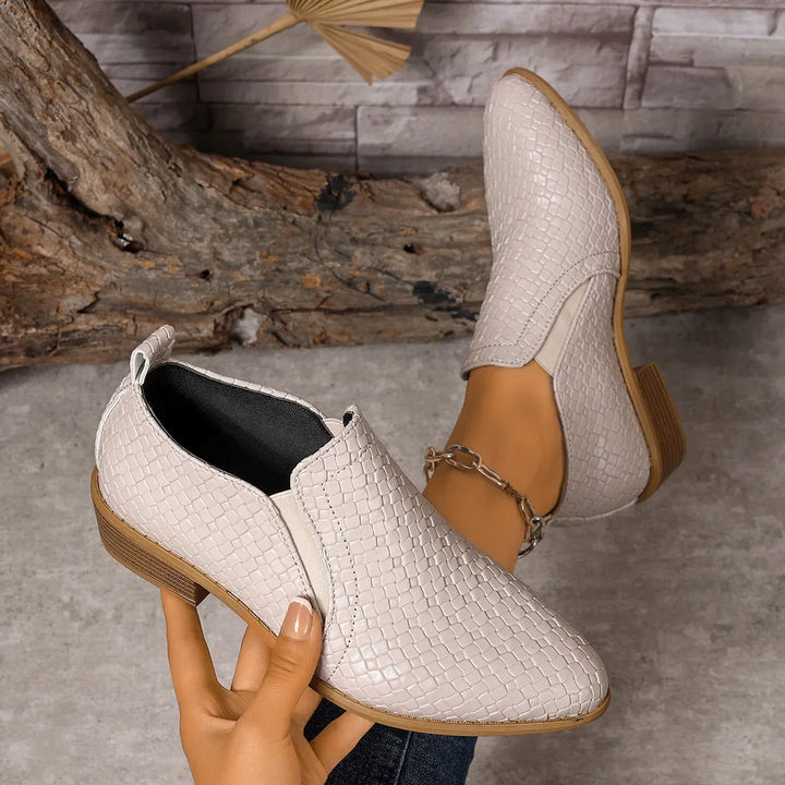 Black leather woven slip-on ankle boots for women, combining fashion-forward design with practical comfort.