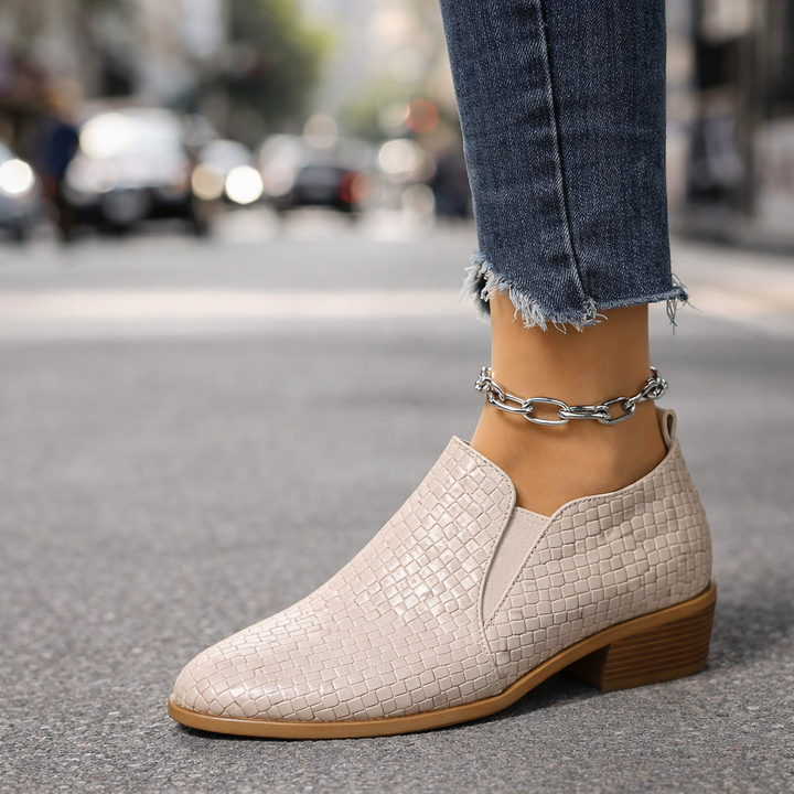 Stylish women's leather ankle boots, featuring a unique woven design and a practical slip-on style.