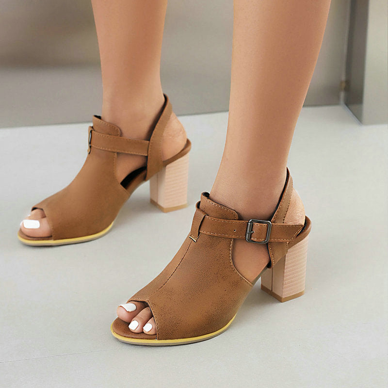 Close-up of a women's silver open-toe block heel, highlighting the adjustable ankle strap and texture.