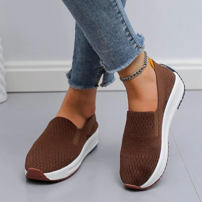 Woman's feet wearing blue orthopedic slip-on walking shoes, showing easy on/off design