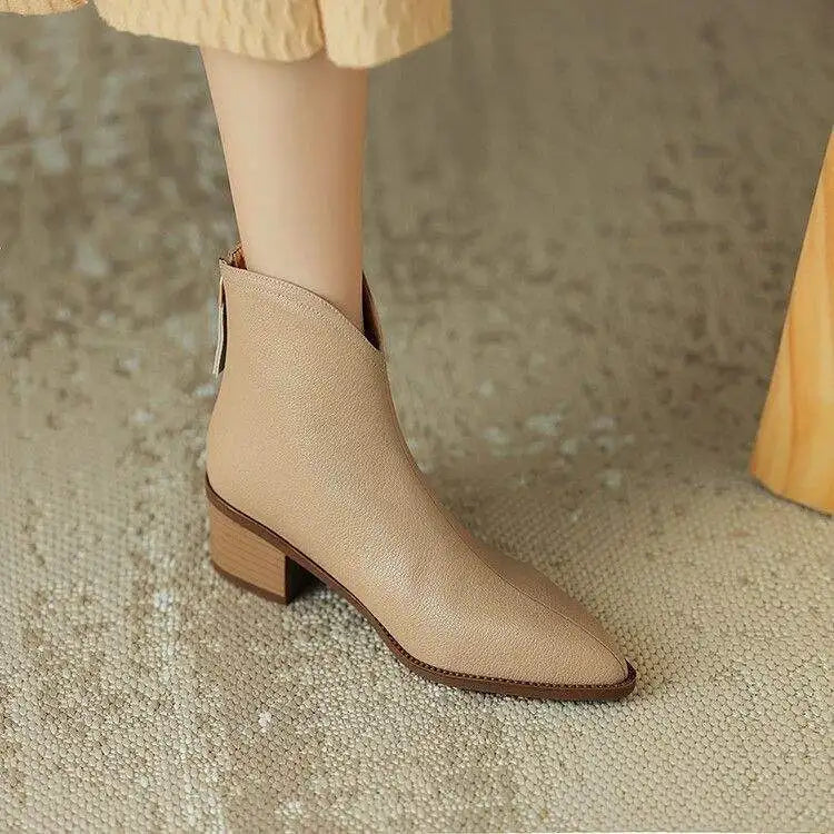 Women's pointed toe, low heel ankle boots with slip-on closure, professional look.