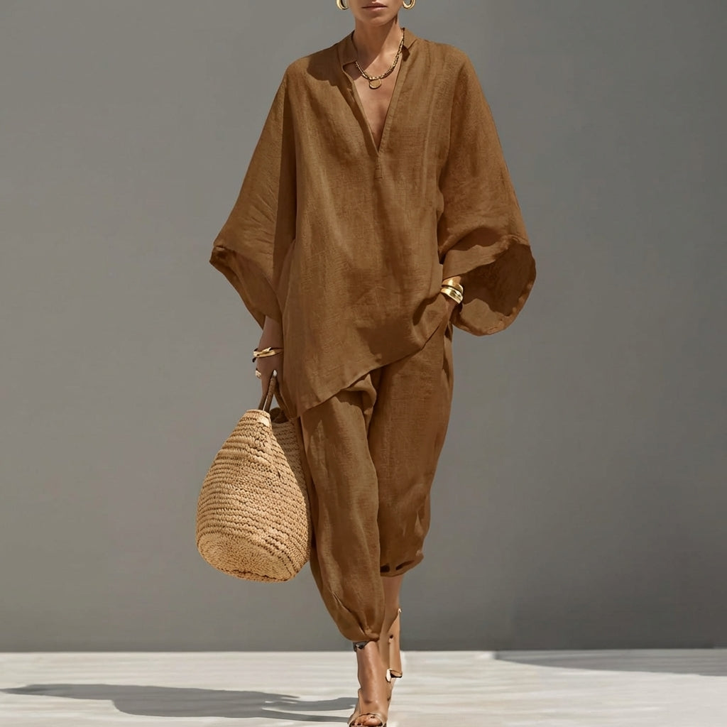 Minimalist black women's two-piece set: an oversized tunic and tapered pants for a modern, relaxed look.