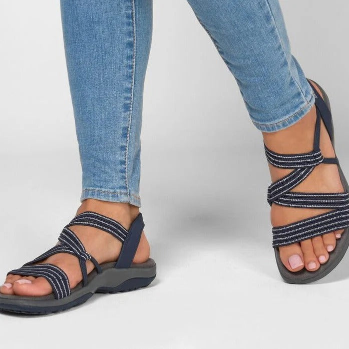 Fashionable women's strappy flat sandals in a neutral tone, designed for everyday casual outdoor comfort.