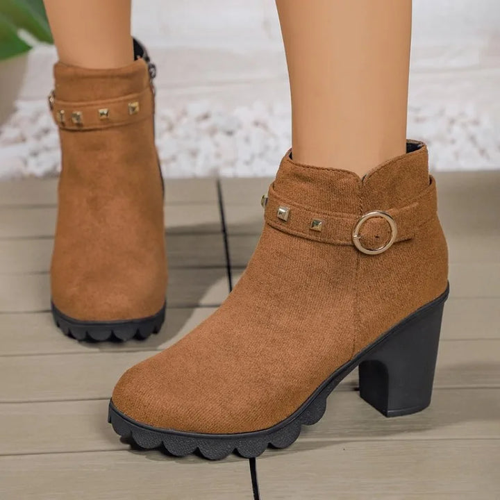 Side view of women's black studded block heel fashion boots on a white background