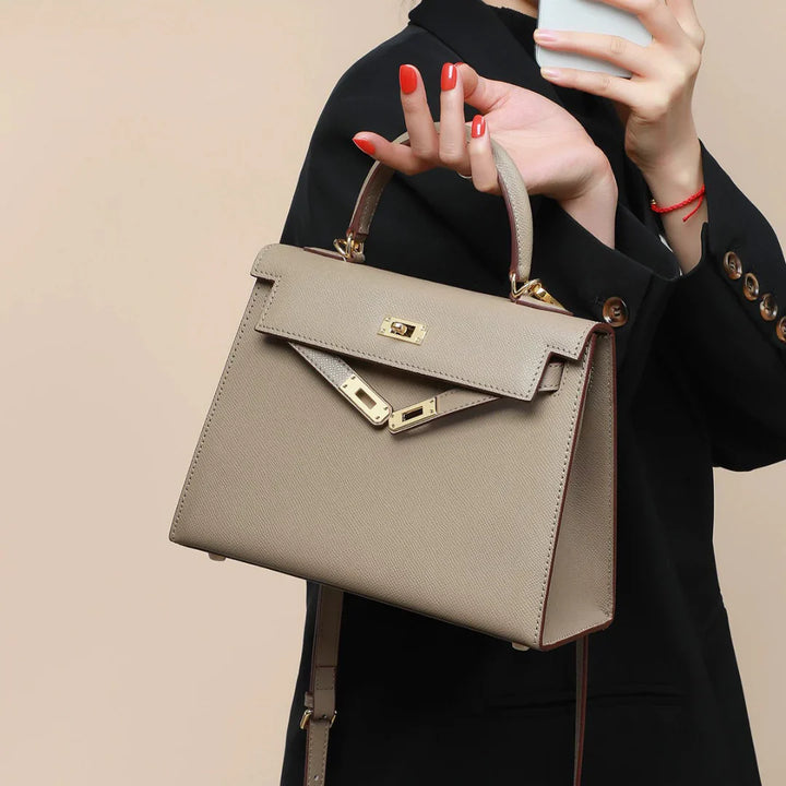 Chic beige structured handbag for women. Versatile top handle & crossbody design with sleek turn lock. Fashion accessory.