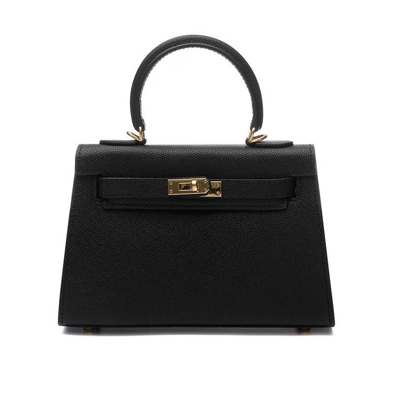 Elegant women's vegan leather crossbody bag. Top handle & shoulder strap, secure turn lock. Structured fashion accessory.