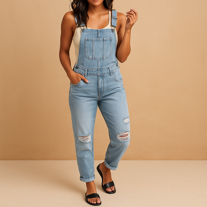 Comfortable women's ripped denim overalls in a stylish blue wash. Distressed details, perfect for casual streetwear.