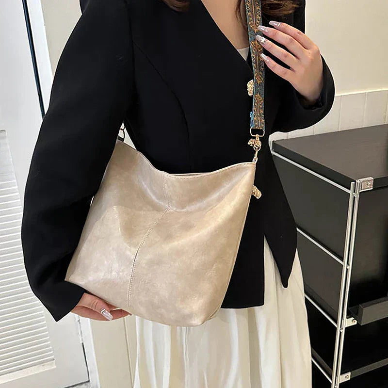 Faux leather slouchy bohemian shoulder bag for women, featuring a vibrant patterned strap.