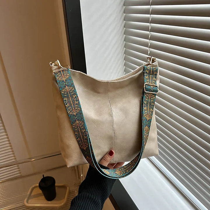 Vibrant women's bohemian shoulder bag, a stylish accessory with an eye-catching patterned strap.