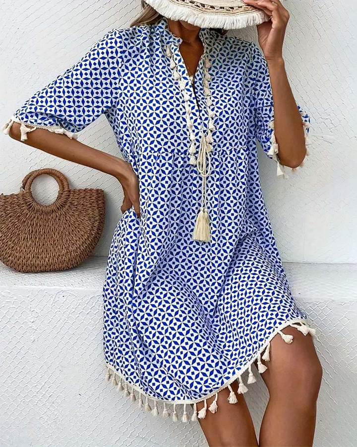Casual women's boho mini dress featuring a geometric pattern & tassel trim, ideal for beach vacations.