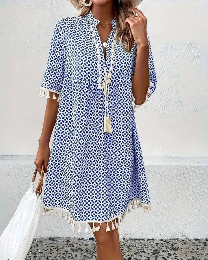 Flowy women's mini boho tunic dress, featuring a unique geometric print and stylish tassel details for summer.