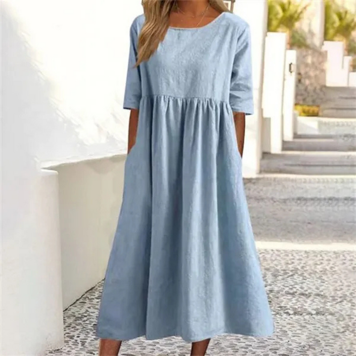 Women's breezy smocked-waist summer midi dress with short sleeves & pockets for casual wear.