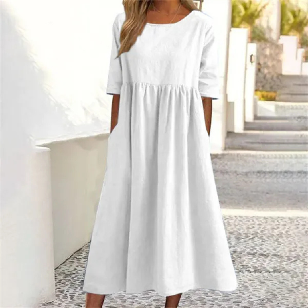 Stylish women's midi summer dress with a smocked waist, short sleeves, breezy fabric, and functional pockets.