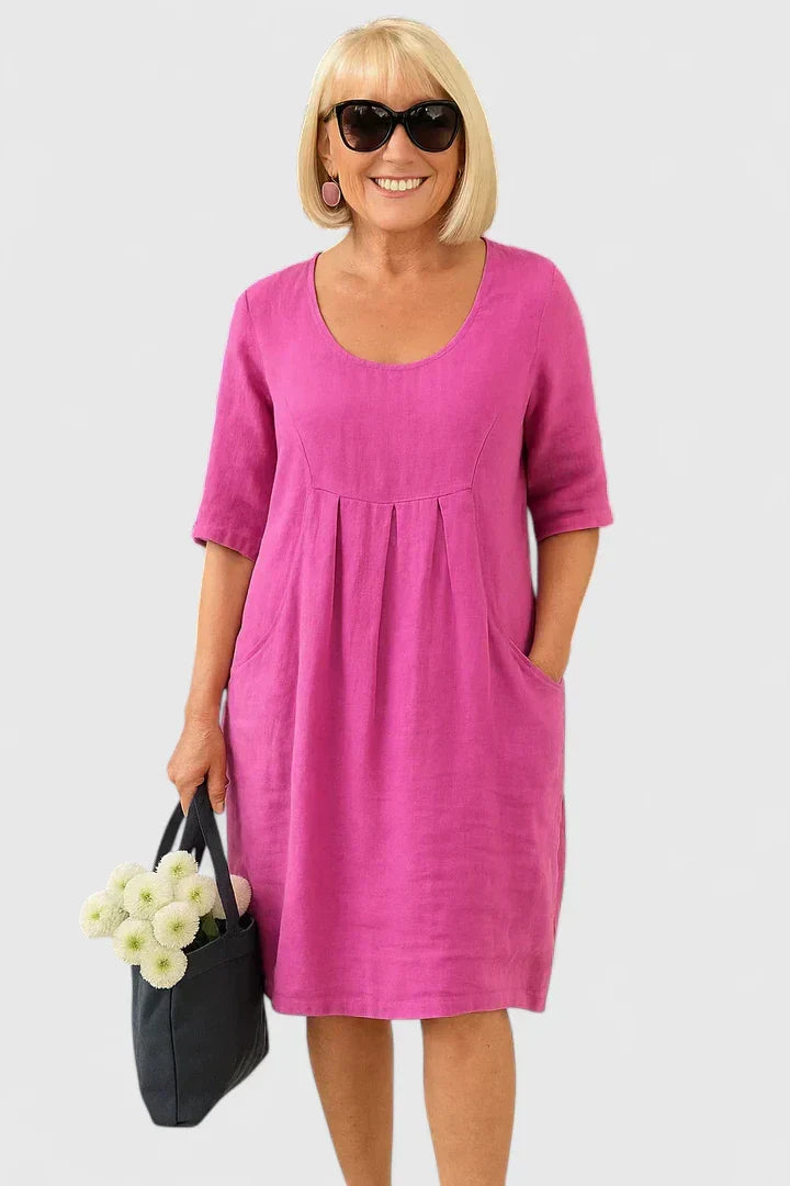 Comfortable women's A-line midi summer dress with convenient pockets, empire waist, and relaxed fit for casual style.