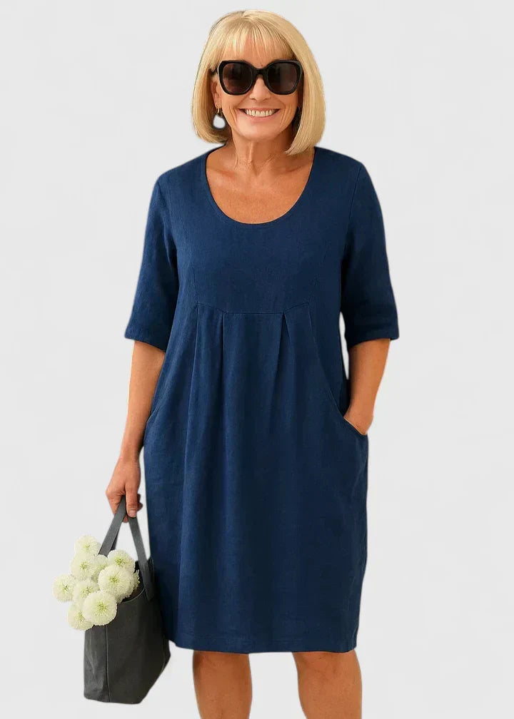 Relaxed fit A-line midi dress for women, ideal for summer, with practical pockets and a flattering empire waist.