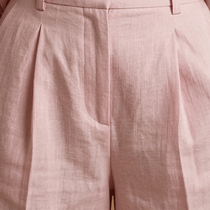 Elegant pleated high-waist shorts and matching long sleeve shirt, a perfect women's casual outfit set.