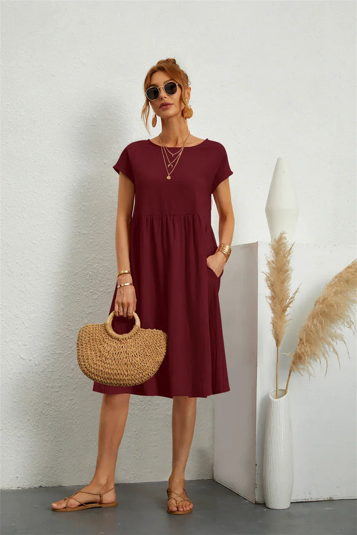 Flattering loose-fit women's midi dress. Short sleeve, tiered design with pockets for casual comfort.